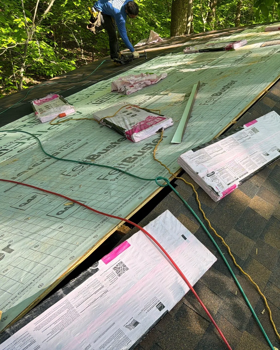 Roof underlayment, shingles, and installation paperwork staged during replacement work