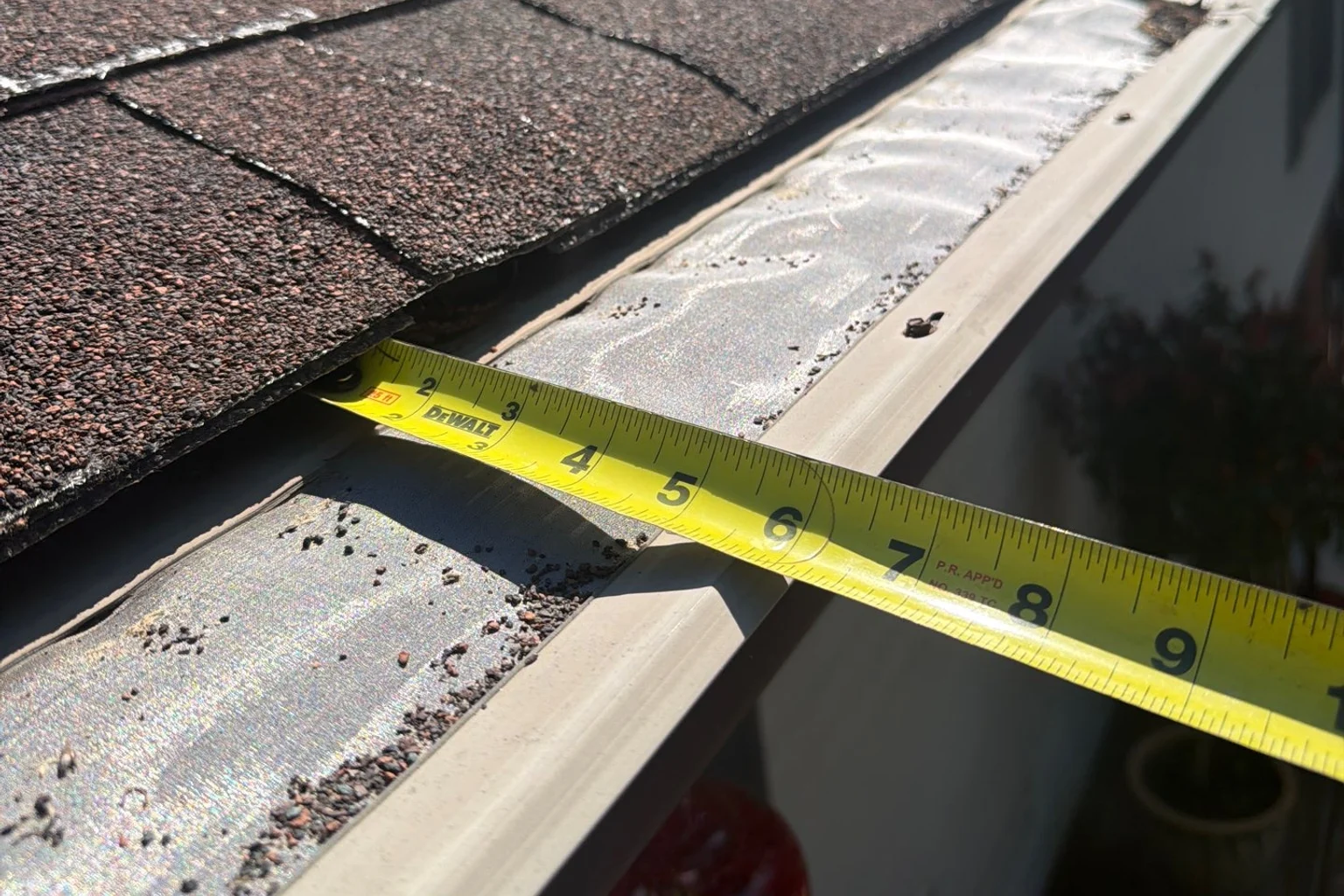 Tape measure checking a residential K-style gutter edge