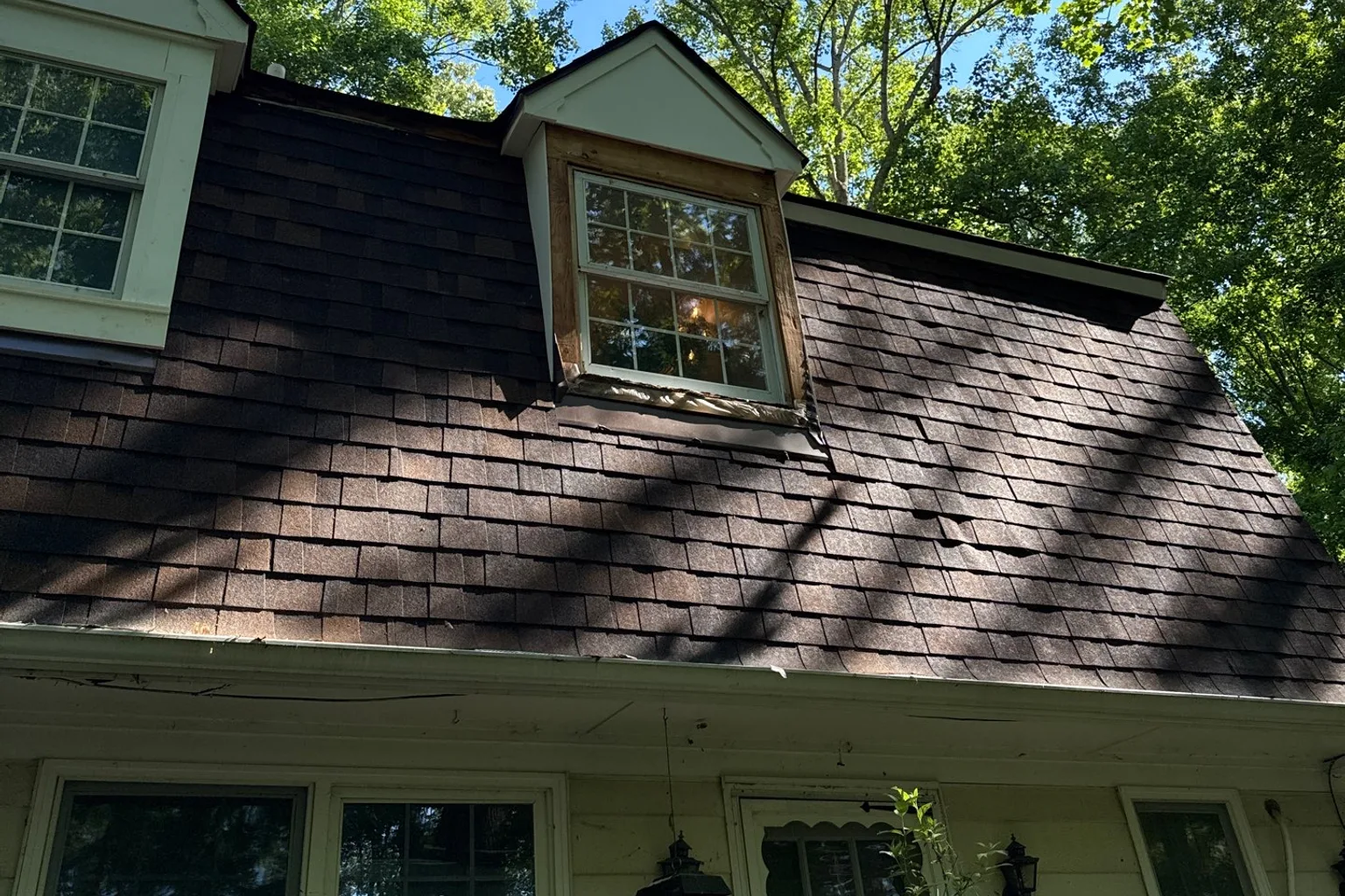 Close view of dormer flashing and roof shingles during inspection
